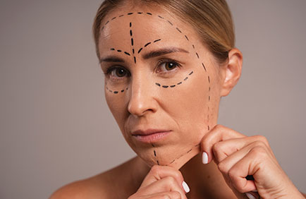 Mulher puxa a pele do queixo para mostrar a flacidez da região e a necessidade de fazer preenchimento facial